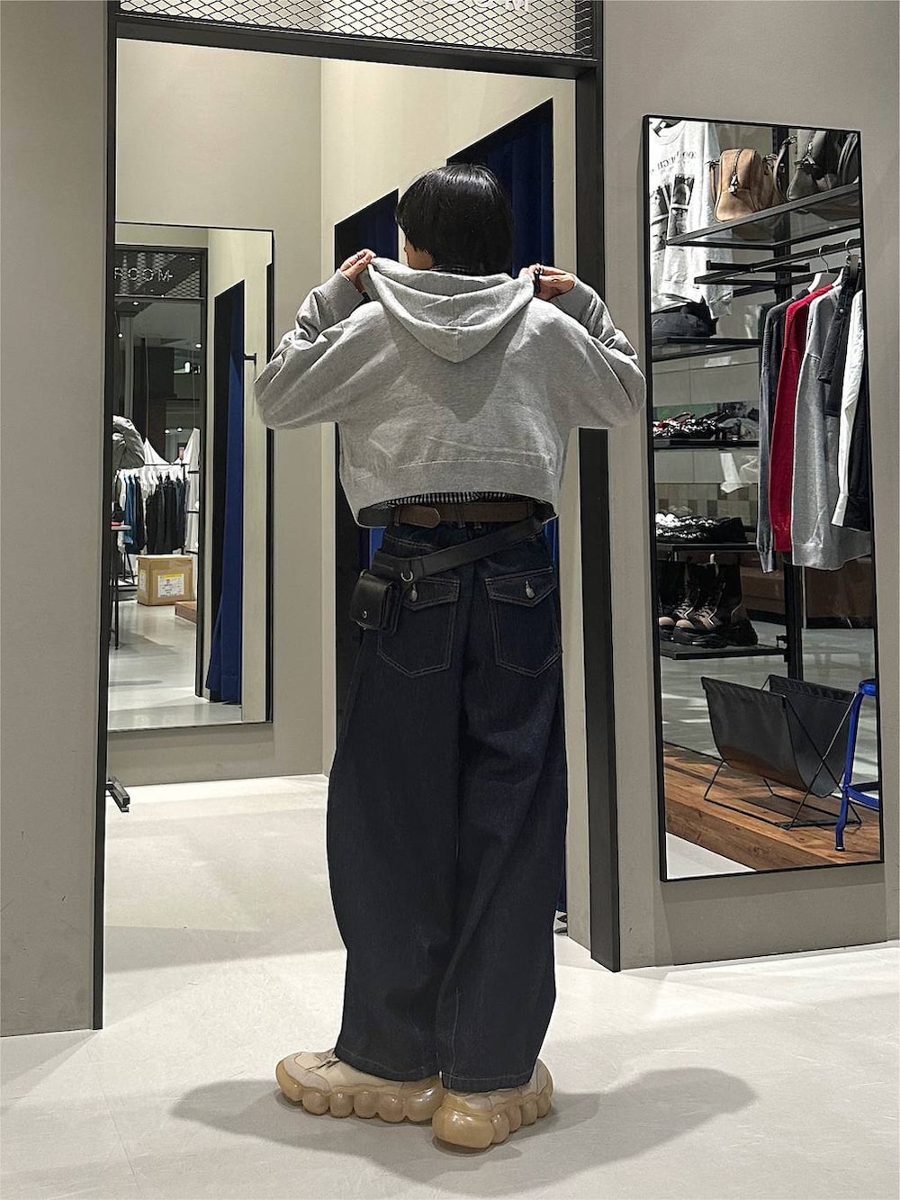グレー系のパーカー、ブルー系のデニムパンツ、ブラック系のボディバッグ/ウエストポーチを着用したメンズの秋コーディネートの5枚目の写真
