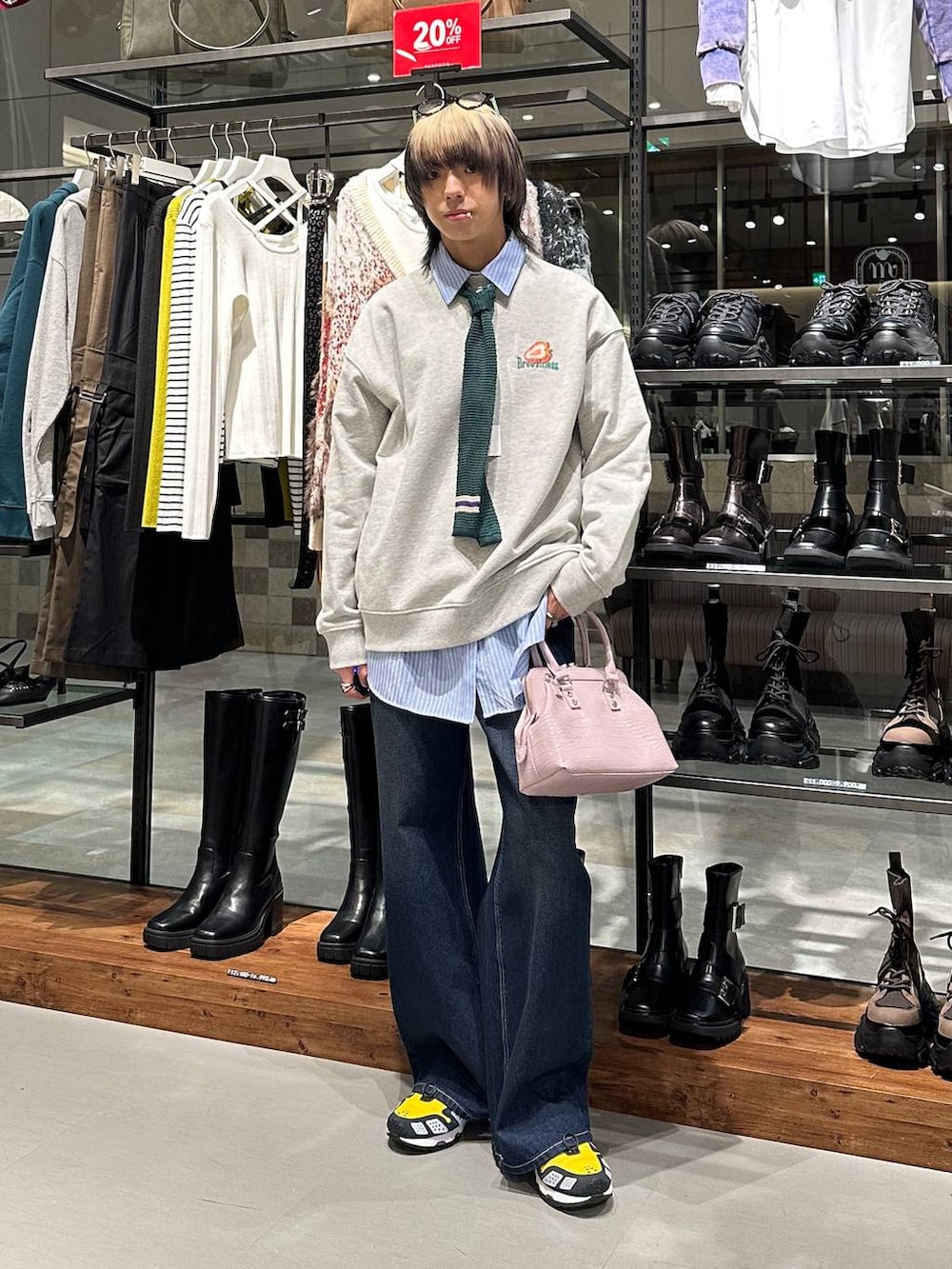 ブルー系のスラックス、ピンク系のハンドバッグ、グレー系のスウェットを着用したメンズの冬コーディネートの2枚目の写真