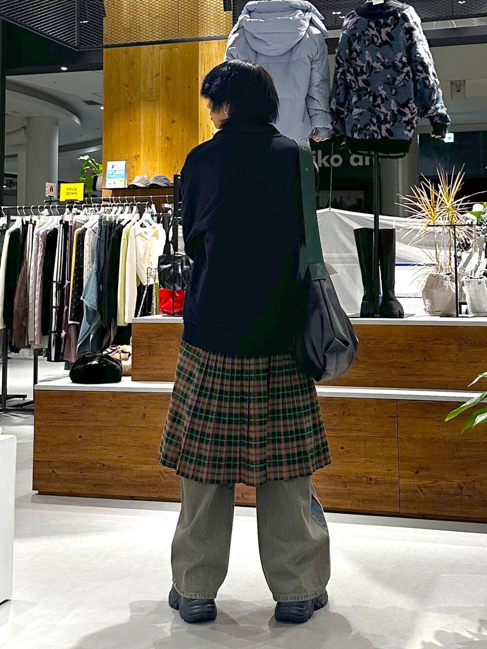 ブルー系のデニムパンツ、ブラウン系のブーツ、ブラック系のトートバッグを着用したメンズの秋コーディネートの5枚目の写真