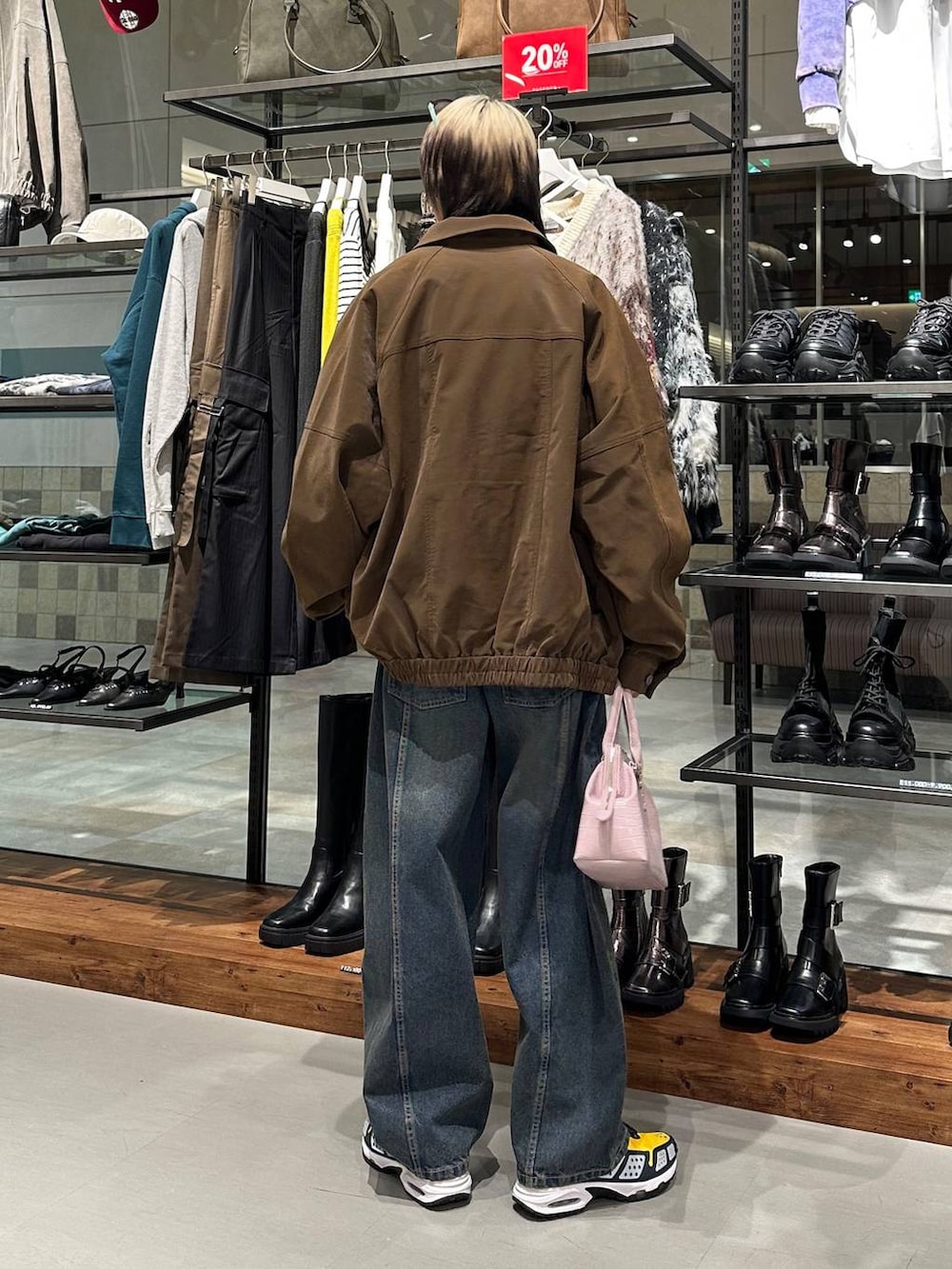 ブルー系のデニムパンツ、ピンク系のハンドバッグ、ベージュ系のスウェットを着用したメンズの冬コーディネートの5枚目の写真