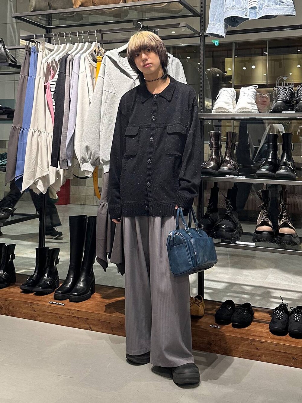 グレー系のデニムパンツ、ブルー系のショルダーバッグ、ブラック系のカーディガン/ボレロを着用したメンズの冬コーディネートの2枚目の写真