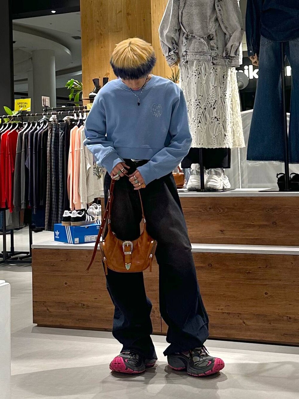 ブルー系のデニムパンツ、ブルー系のスウェット、ブラウン系のショルダーバッグを着用したメンズの春コーディネートの2枚目の写真