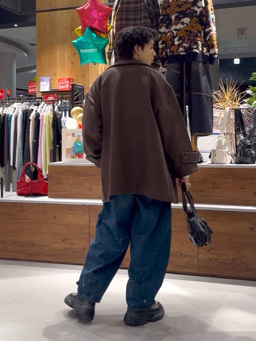 ホワイト系のニット/セーター、ブラウン系のテーラードジャケット、ブルー系のデニムパンツを着用したメンズの冬コーディネートの5枚目の写真