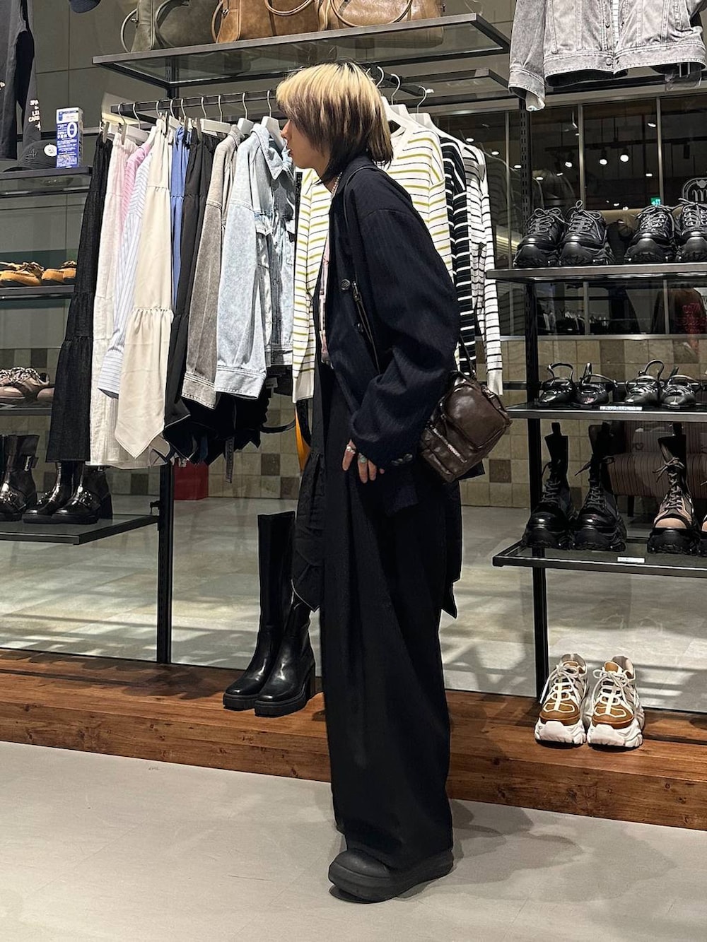 ブラック系のスラックス、ブラウン系のショルダーバッグ、ピンク系のTシャツ/カットソーを着用したメンズの春コーディネートの4枚目の写真