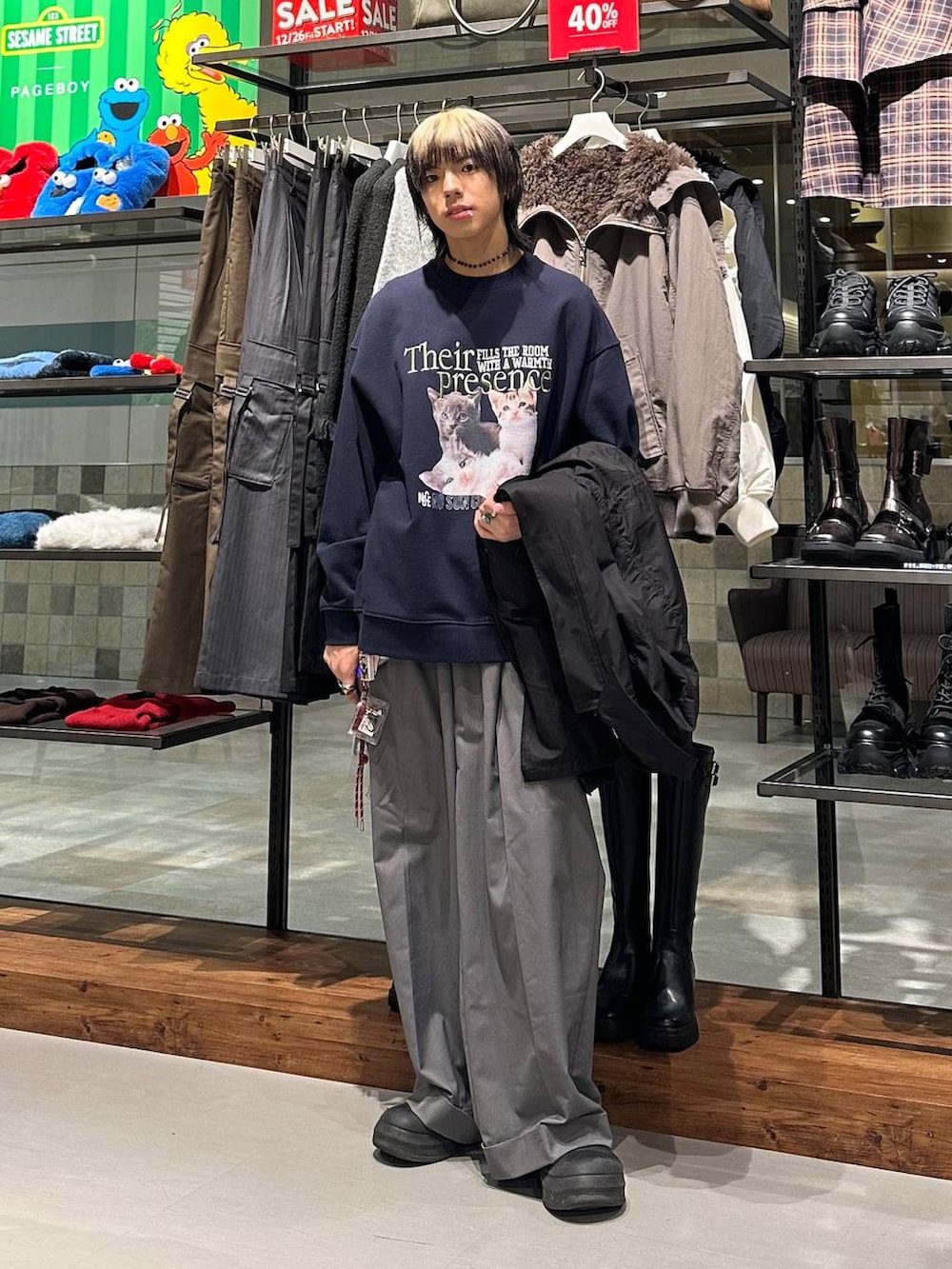 ブラック系のモッズコート、グレー系のスラックス、ブルー系のスウェットを着用したメンズの冬コーディネートの2枚目の写真