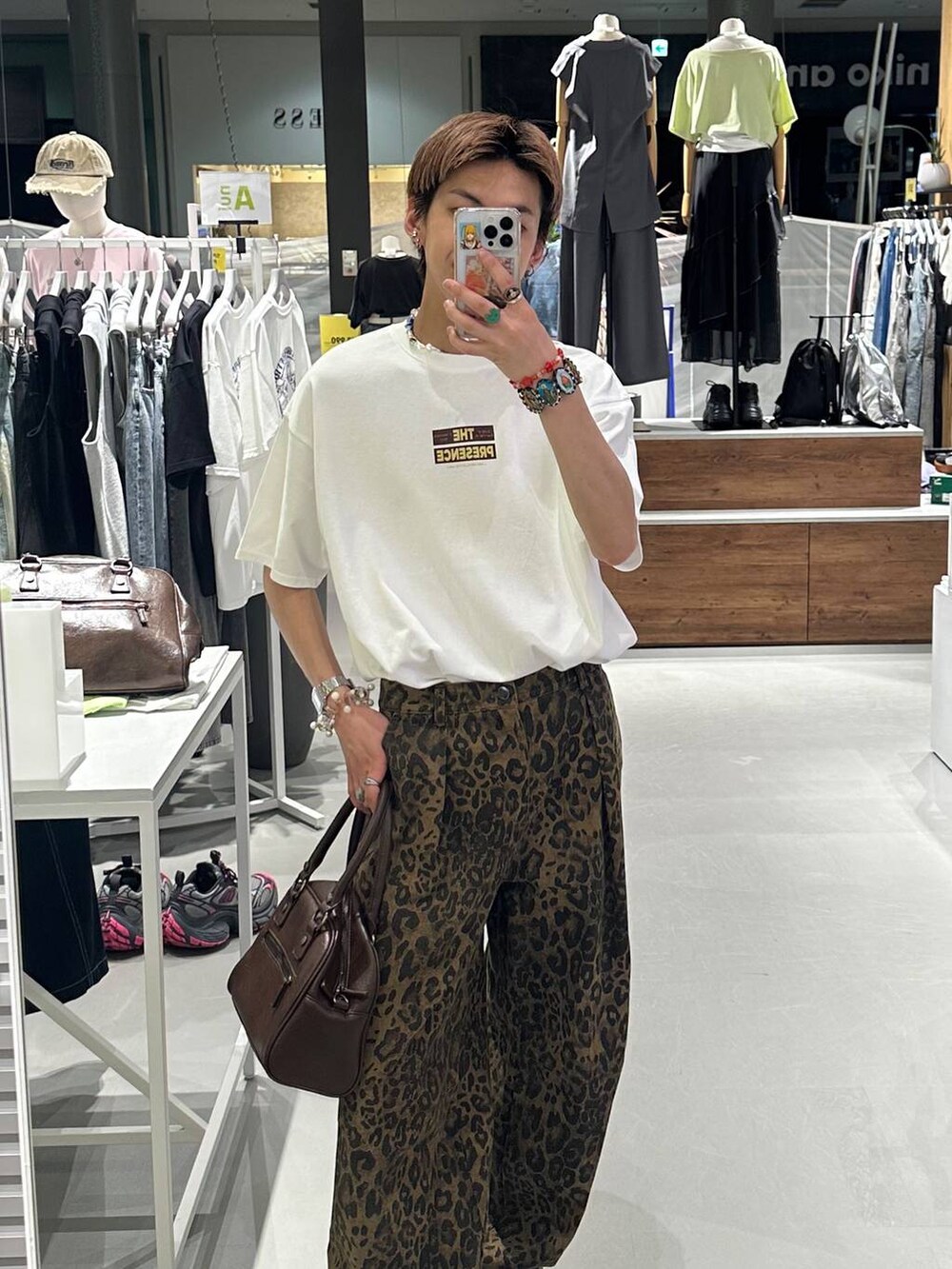 ブラウン系のボストンバッグ、その他のデニムパンツ、ホワイト系のTシャツ/カットソーを着用したメンズの夏コーディネートの2枚目の写真