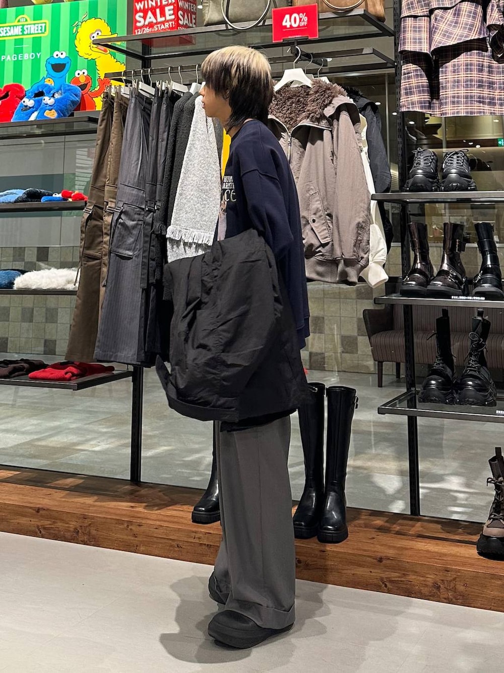 ブラック系のモッズコート、グレー系のスラックス、ブルー系のスウェットを着用したメンズの冬コーディネートの3枚目の写真