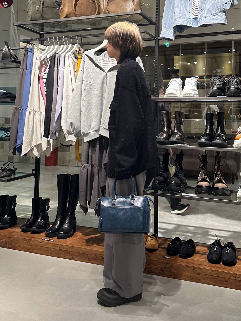 グレー系のデニムパンツ、ブルー系のショルダーバッグ、ブラック系のカーディガン/ボレロを着用したメンズの冬コーディネートの4枚目の写真