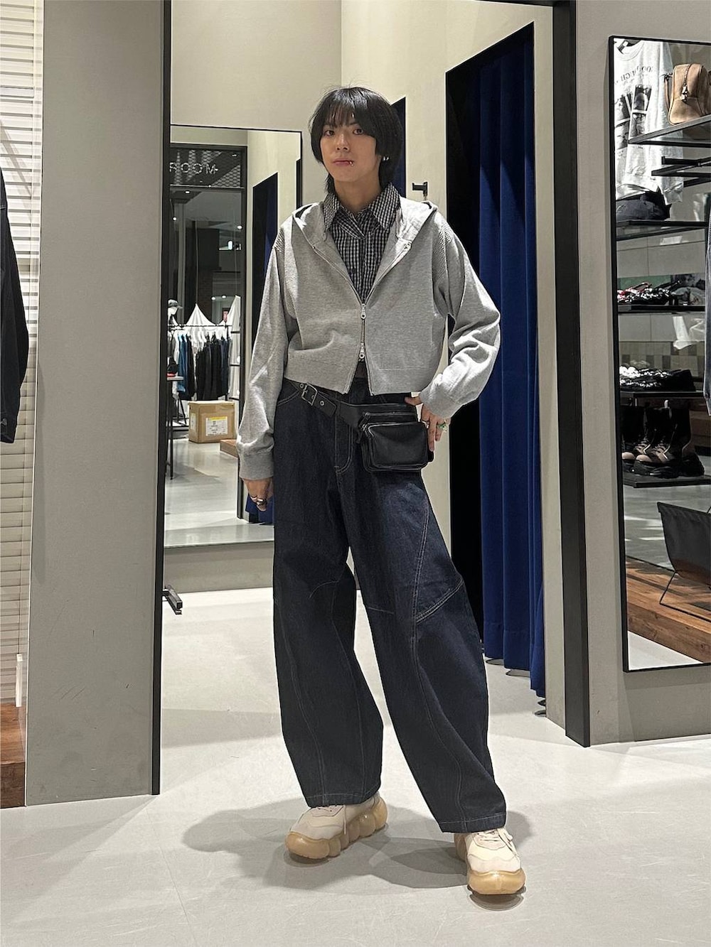 グレー系のパーカー、ブルー系のデニムパンツ、ブラック系のボディバッグ/ウエストポーチを着用したメンズの秋コーディネートの2枚目の写真