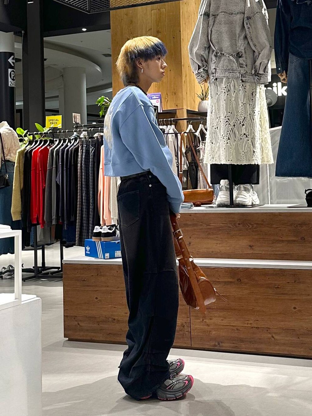 ブルー系のデニムパンツ、ブルー系のスウェット、ブラウン系のショルダーバッグを着用したメンズの春コーディネートの4枚目の写真