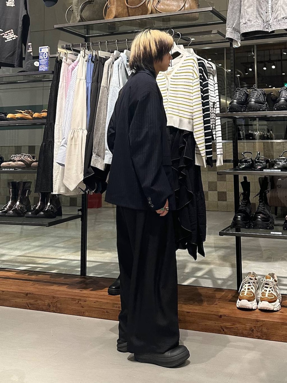 ブラック系のスラックス、ブラウン系のショルダーバッグ、ピンク系のTシャツ/カットソーを着用したメンズの春コーディネートの3枚目の写真