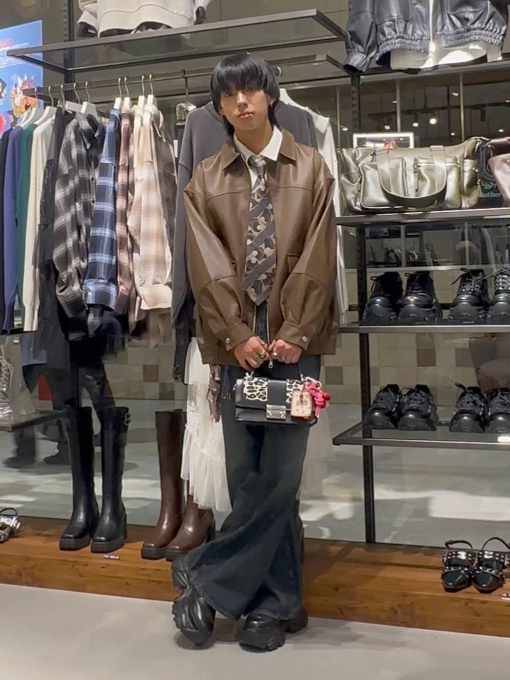 ブルー系のデニムパンツ、その他のハンドバッグ、ブラウン系のブルゾンを着用したメンズの秋コーディネートの2枚目の写真