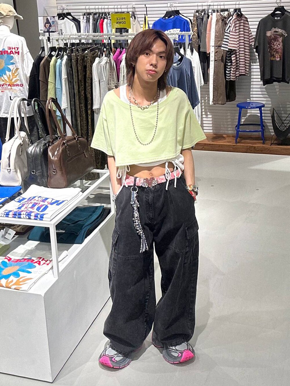 ブラック系のカーゴパンツ、グリーン系のTシャツ/カットソー、ブラック系のネックレスを着用したメンズの春コーディネートの2枚目の写真