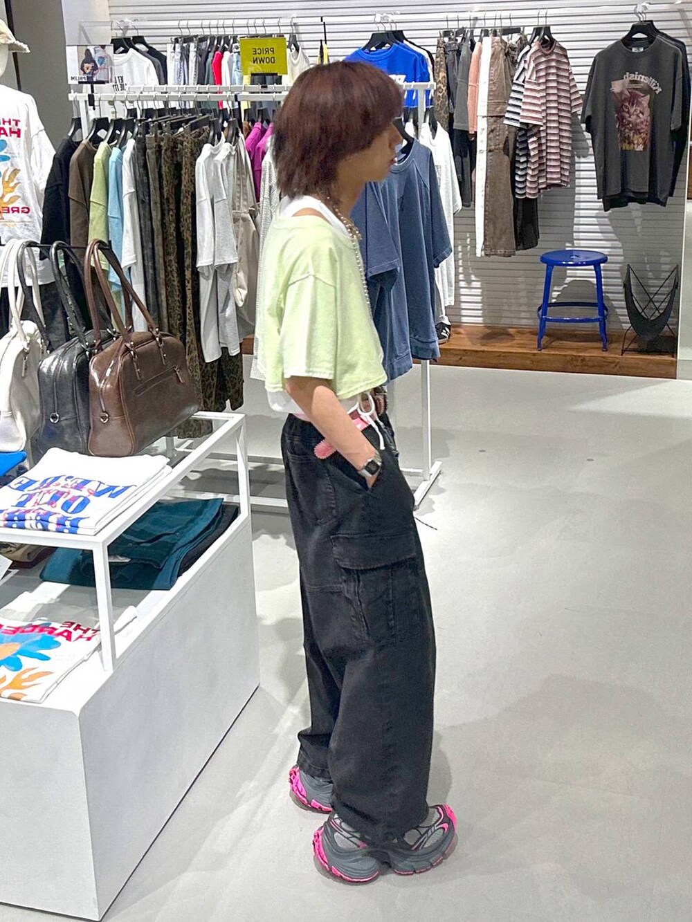 ブラック系のカーゴパンツ、グリーン系のTシャツ/カットソー、ブラック系のネックレスを着用したメンズの春コーディネートの3枚目の写真