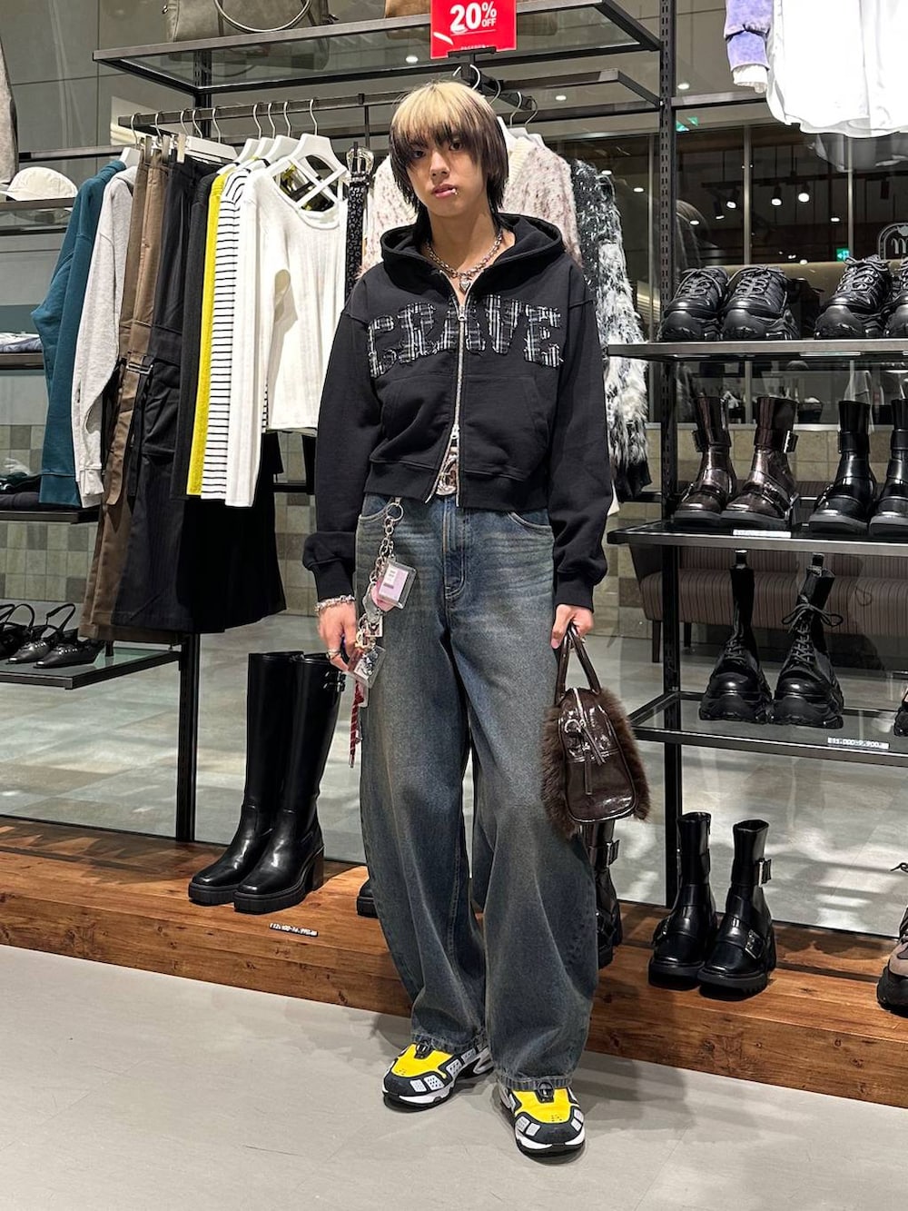 ブラウン系のボストンバッグ、ブルー系のデニムパンツ、ブラック系のパーカーを着用したメンズの冬コーディネートの2枚目の写真