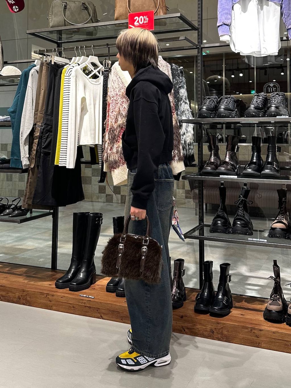 ブラウン系のボストンバッグ、ブルー系のデニムパンツ、ブラック系のパーカーを着用したメンズの冬コーディネートの3枚目の写真