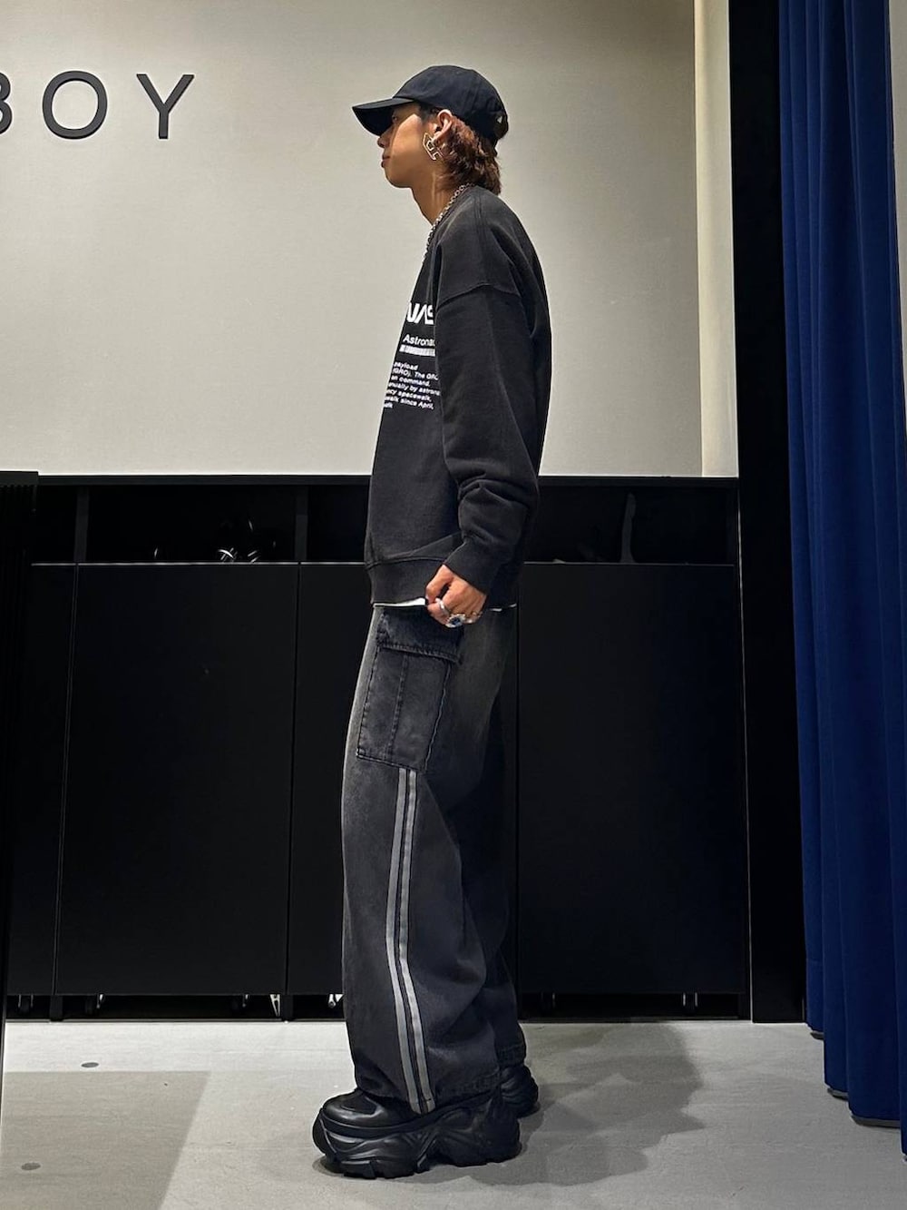 ブラック系のデニムパンツ、ブラック系のスウェット、シルバー系のネックレスを着用したメンズの秋コーディネートの2枚目の写真