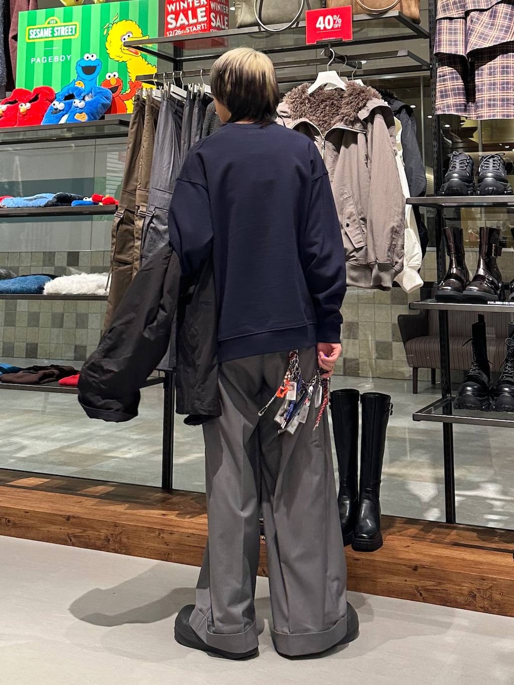 ブラック系のモッズコート、グレー系のスラックス、ブルー系のスウェットを着用したメンズの冬コーディネートの5枚目の写真