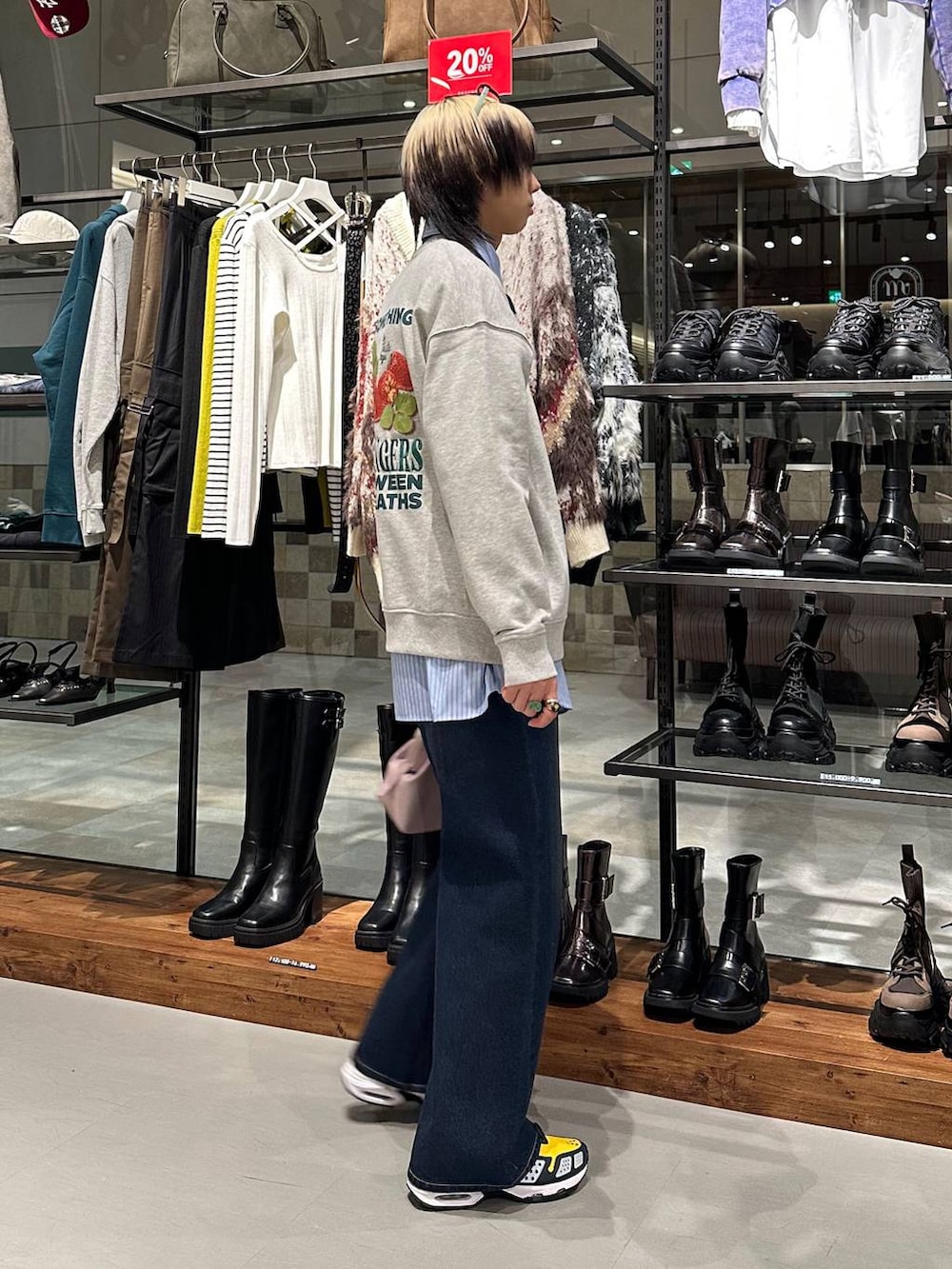 ブルー系のスラックス、ピンク系のハンドバッグ、グレー系のスウェットを着用したメンズの冬コーディネートの3枚目の写真