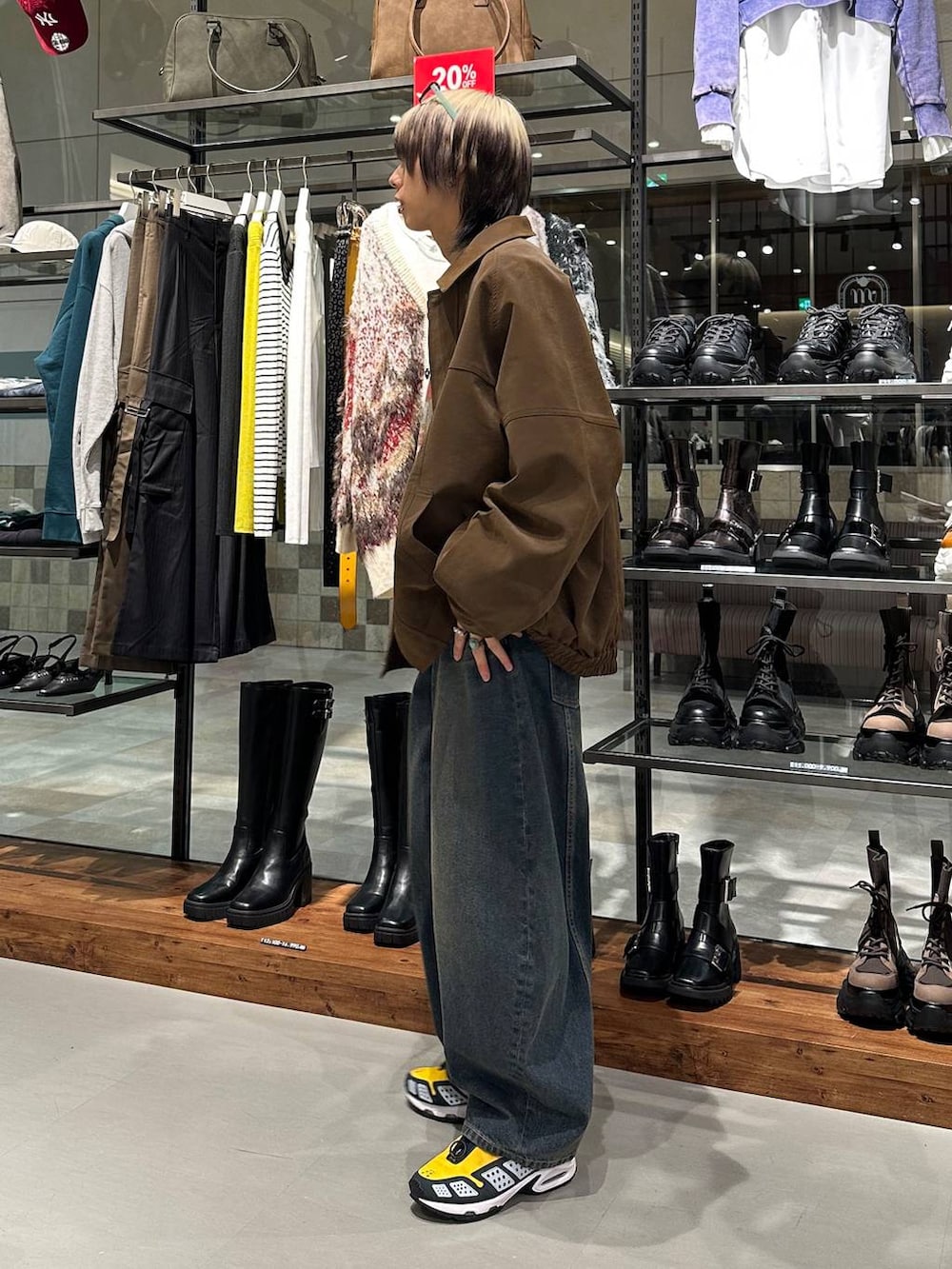 ブルー系のデニムパンツ、ピンク系のハンドバッグ、ベージュ系のスウェットを着用したメンズの冬コーディネートの4枚目の写真