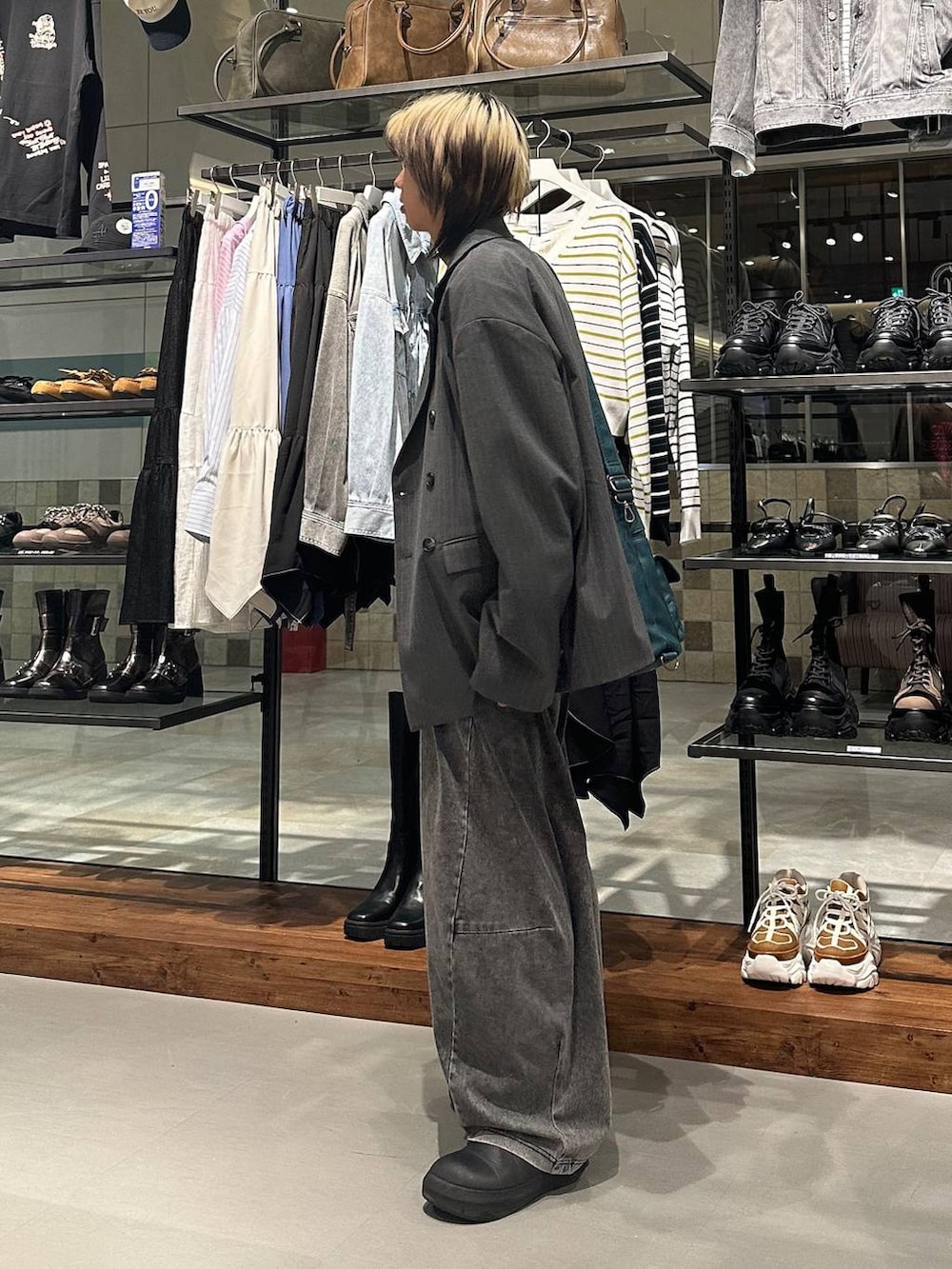 ブルー系のショルダーバッグ、ブラック系のデニムパンツ、ホワイト系のTシャツ/カットソーを着用したメンズの春コーディネートの4枚目の写真