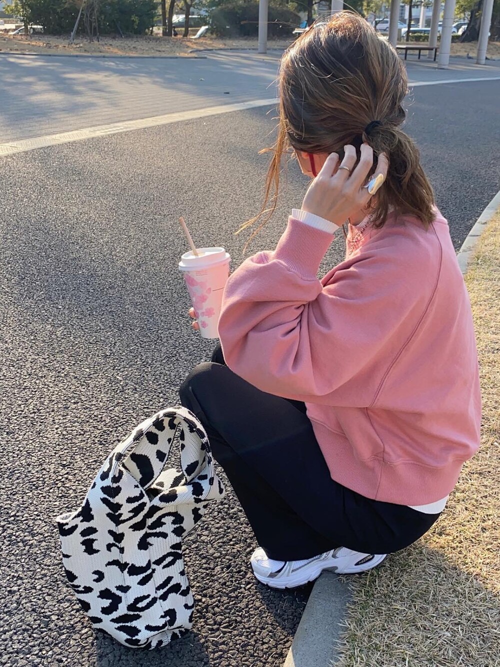 ホワイト系のバッグ、ホワイト系のスニーカー、ブラック系のキャップを着用したレディースの春コーディネートの2枚目の写真