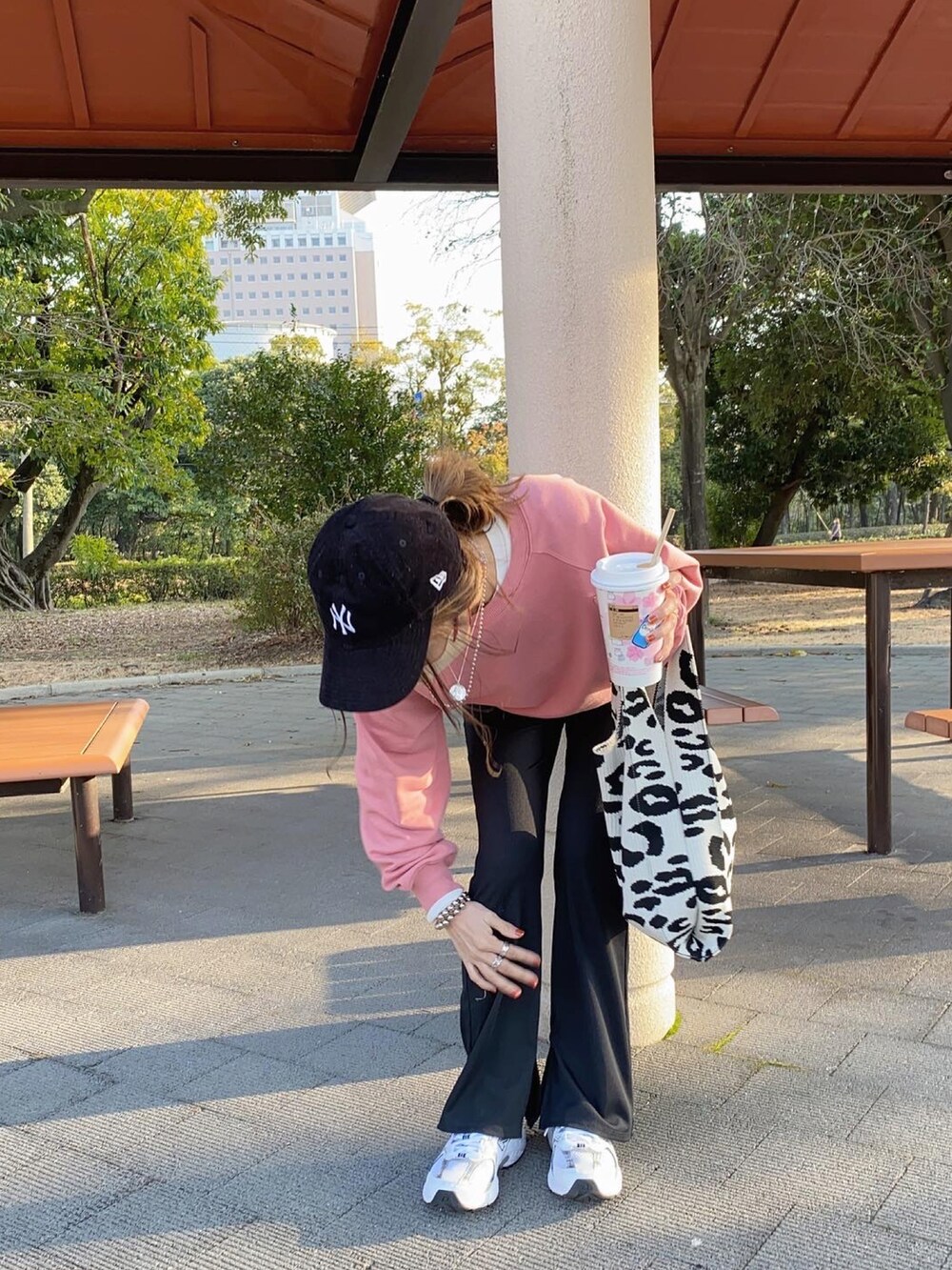 ホワイト系のバッグ、ホワイト系のスニーカー、ブラック系のキャップを着用したレディースの春コーディネートの4枚目の写真