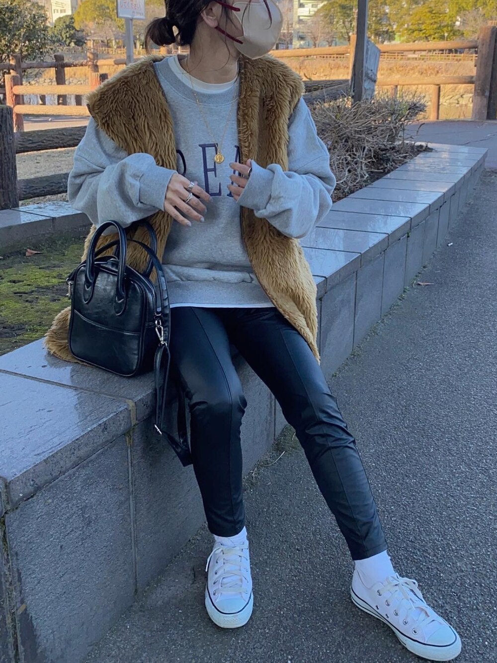 ブラウン系のベスト、ブラック系のその他パンツ、ホワイト系のスニーカーを着用したレディースの冬コーディネートの3枚目の写真