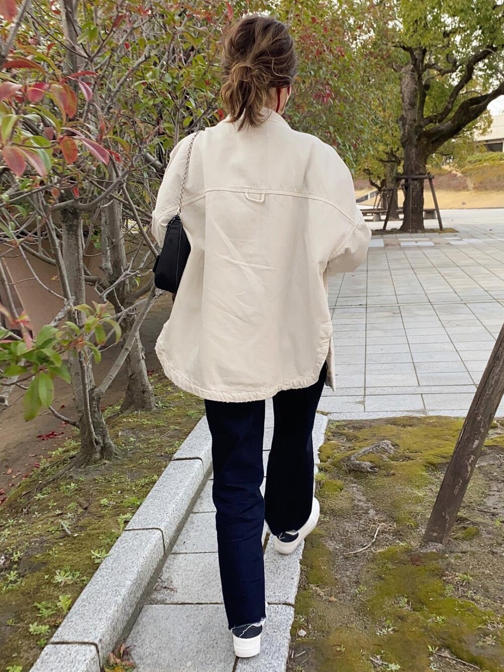 ブルー系のスニーカー、ホワイト系のジャケット/アウター、グリーン系のTシャツ/カットソーを着用したレディースの春コーディネートの2枚目の写真