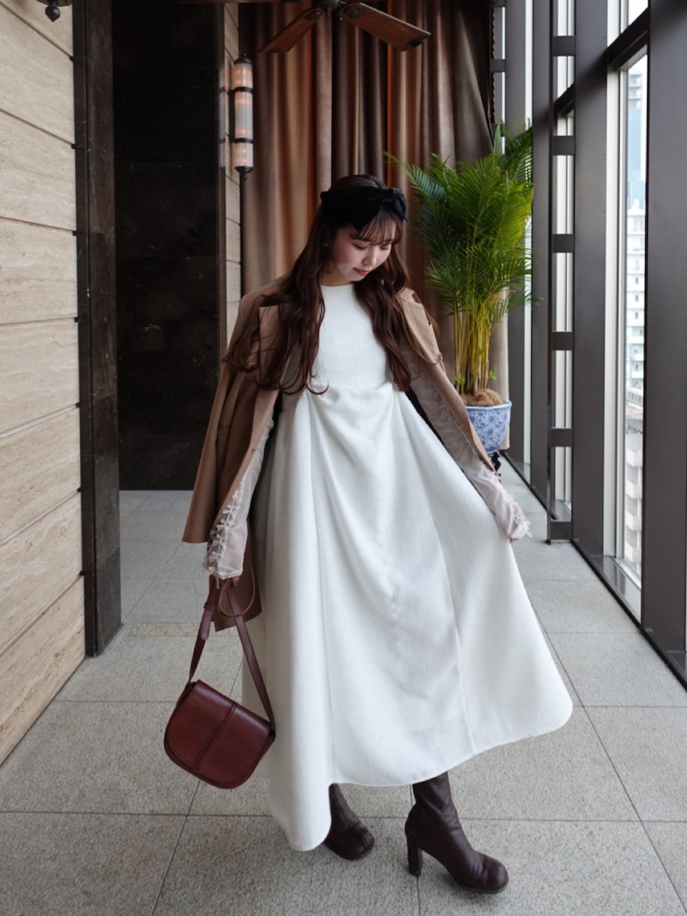 ブラウン系のジャケット/アウター、ホワイト系のワンピース/ドレス、ブラウン系のショルダーバッグを着用したレディースの冬コーディネートの2枚目の写真
