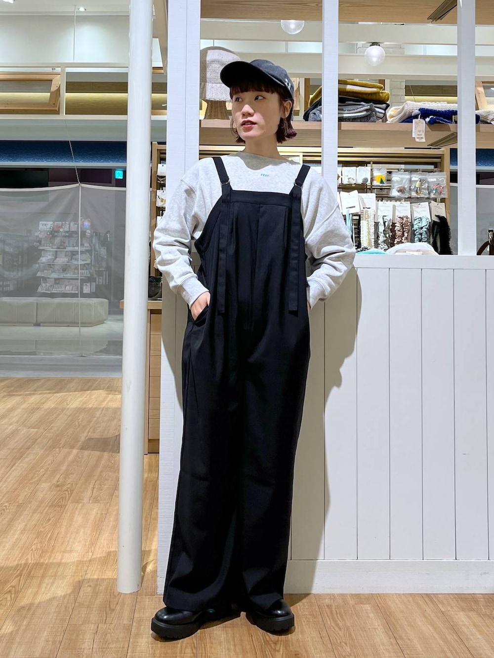 グレー系のスウェット、ブラック系のサロペット/オーバーオール、ブラック系のブーツを着用したレディースの秋コーディネートの4枚目の写真