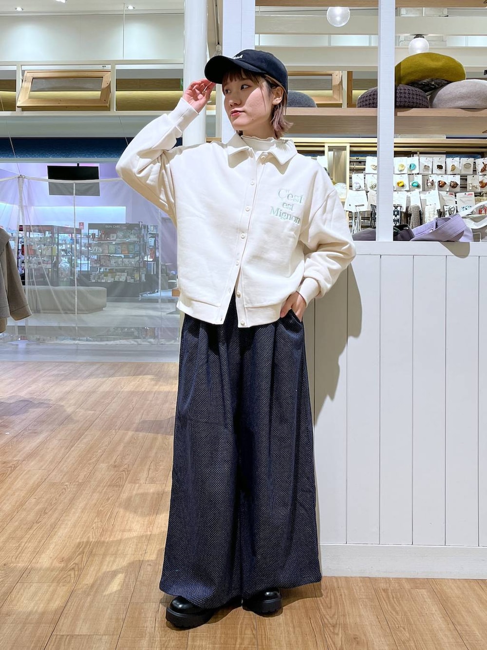 ブラウン系のブルゾン、ホワイト系のTシャツ/カットソー、ブラック系のブーツを着用したレディースの冬コーディネートの4枚目の写真