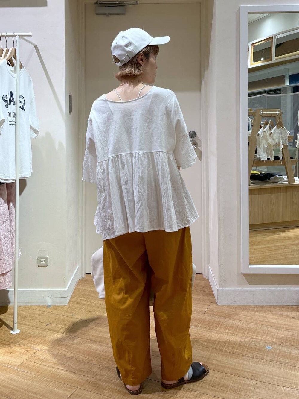 ブラック系のサンダル、イエロー系のその他パンツ、ホワイト系のTシャツ/カットソーを着用したレディースの夏コーディネートの2枚目の写真