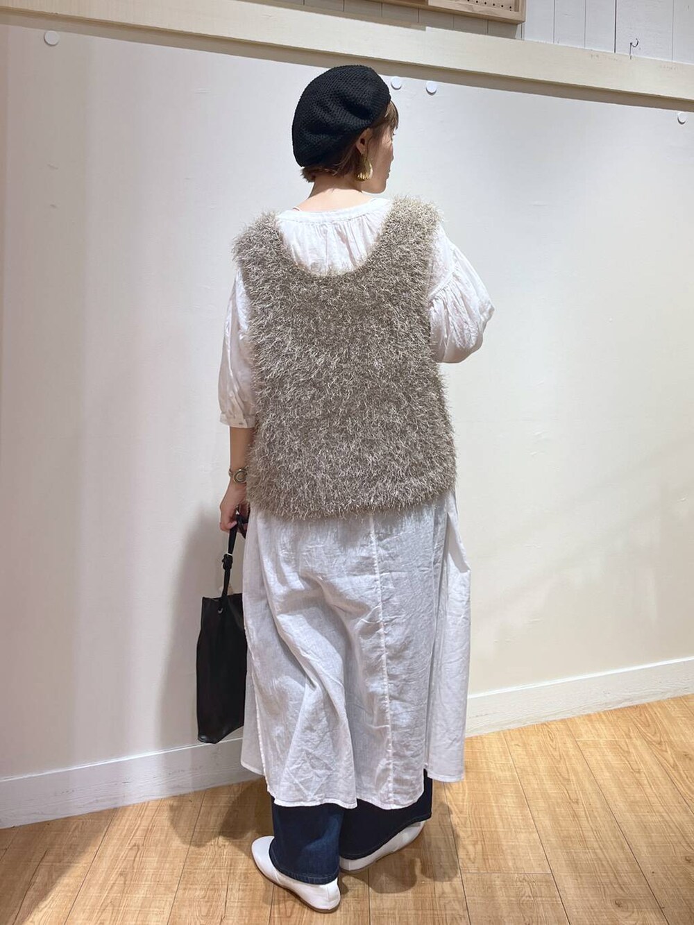 ホワイト系のパンプス、グレー系のベスト、ホワイト系のワンピースを着用したレディースの秋コーディネートの3枚目の写真