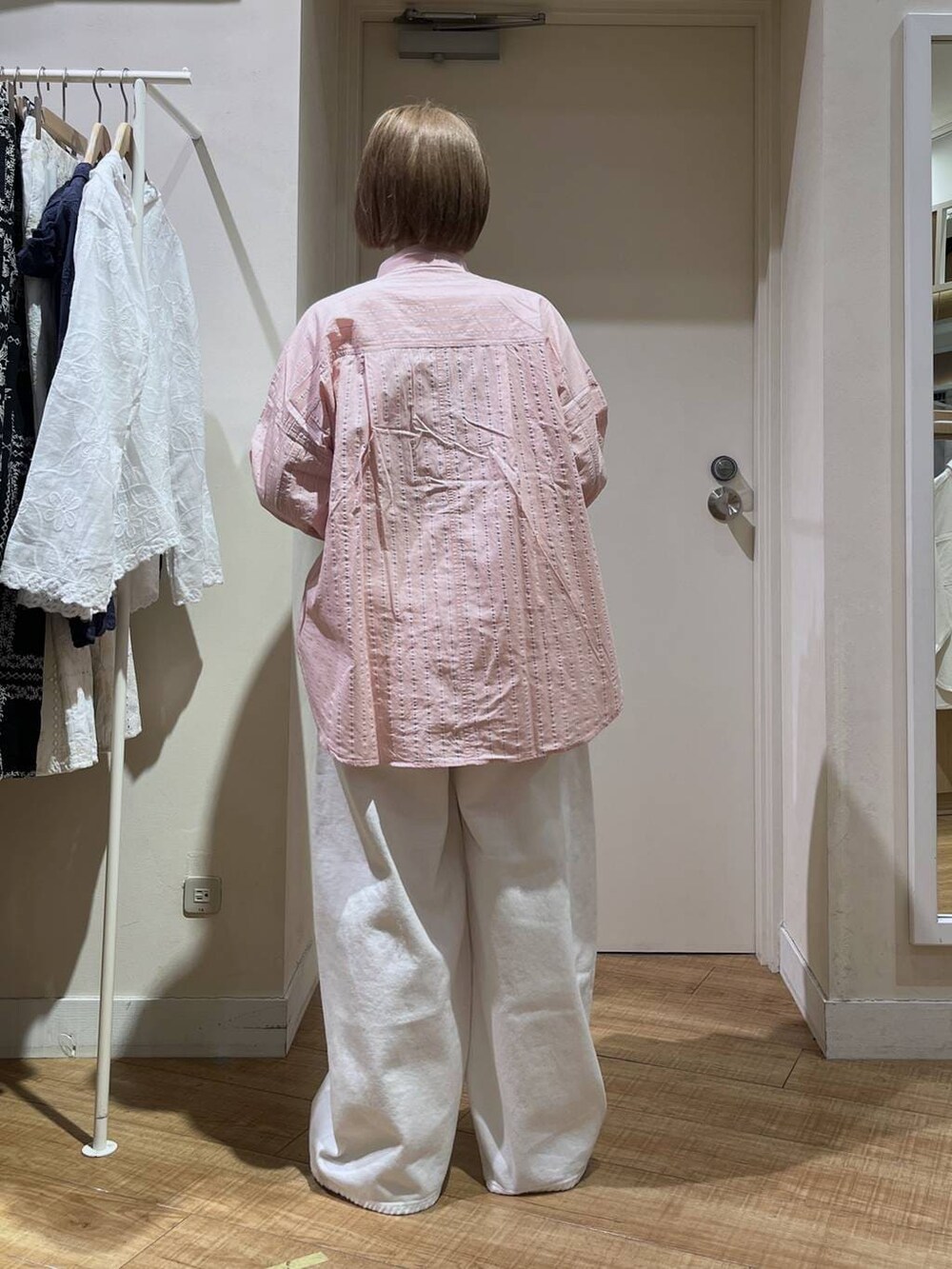 ホワイト系のデニムパンツ、ブルー系のテーラードジャケット、ブラック系のトートバッグを着用したレディースの冬コーディネートの6枚目の写真