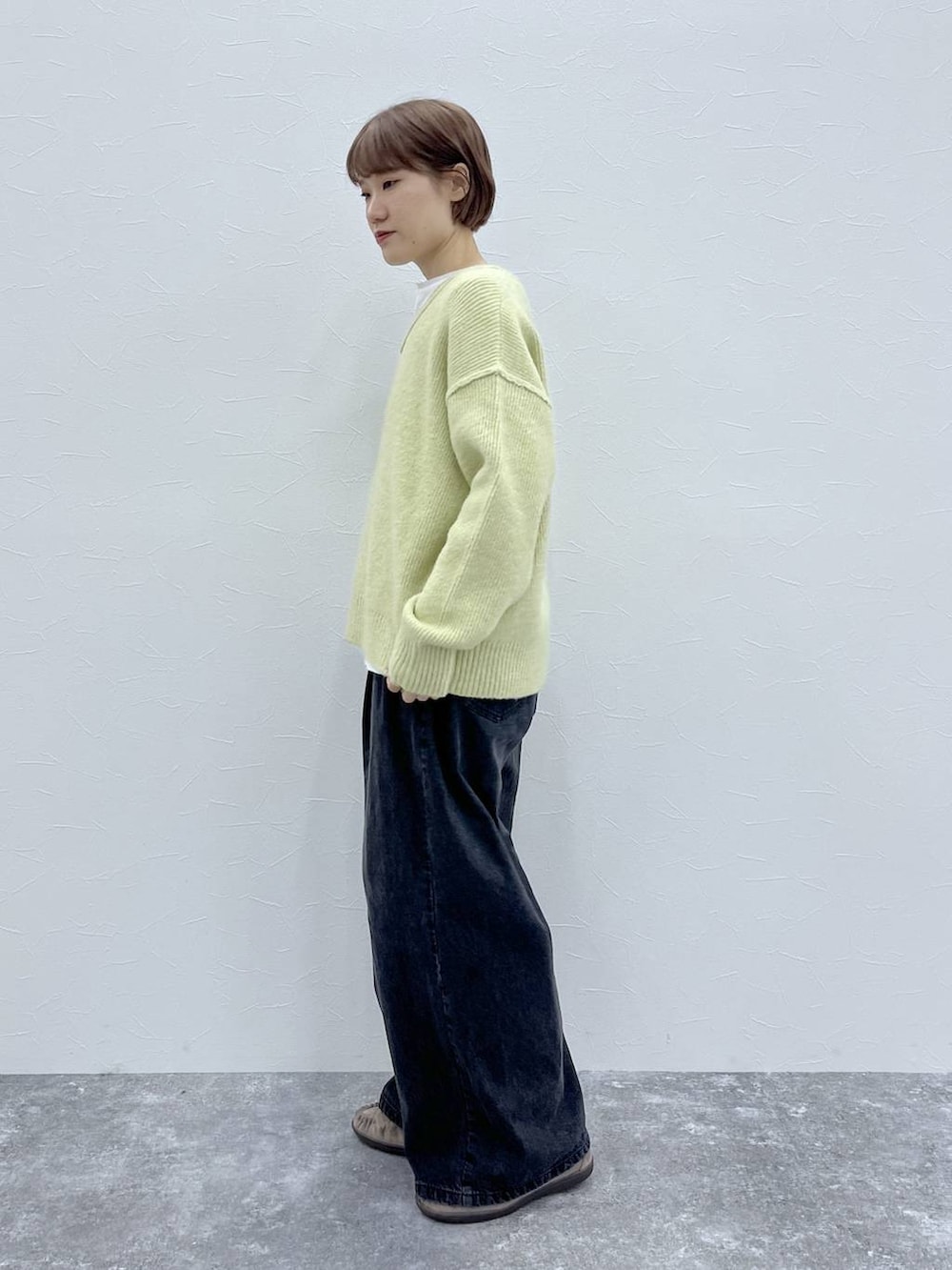 ブラック系のデニムパンツ、イエロー系のその他アウター、グレー系のモカシン/デッキシューズを着用したレディースの秋コーディネートの6枚目の写真