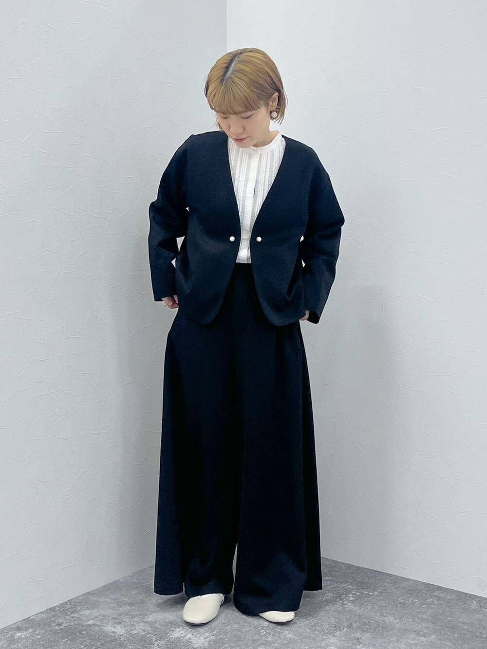 ブラック系のスーツセット、ホワイト系のシャツ/ブラウスを着用したレディースの秋コーディネートの5枚目の写真