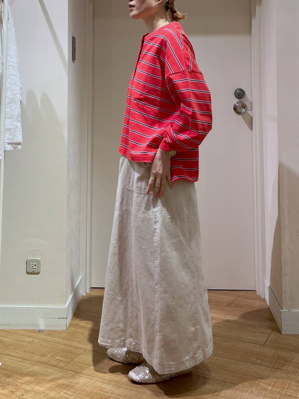 レッド系のTシャツ/カットソー、ホワイト系のバレエシューズ、ベージュ系のカーディガン/ボレロを着用したレディースの春コーディネートの5枚目の写真