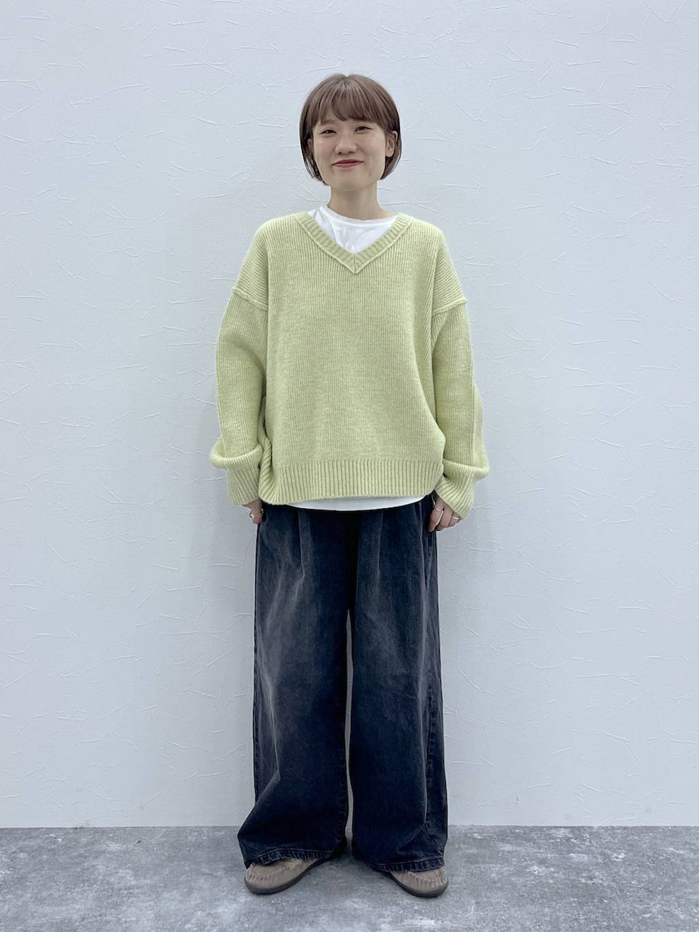 ブラック系のデニムパンツ、イエロー系のその他アウター、グレー系のモカシン/デッキシューズを着用したレディースの秋コーディネートの4枚目の写真