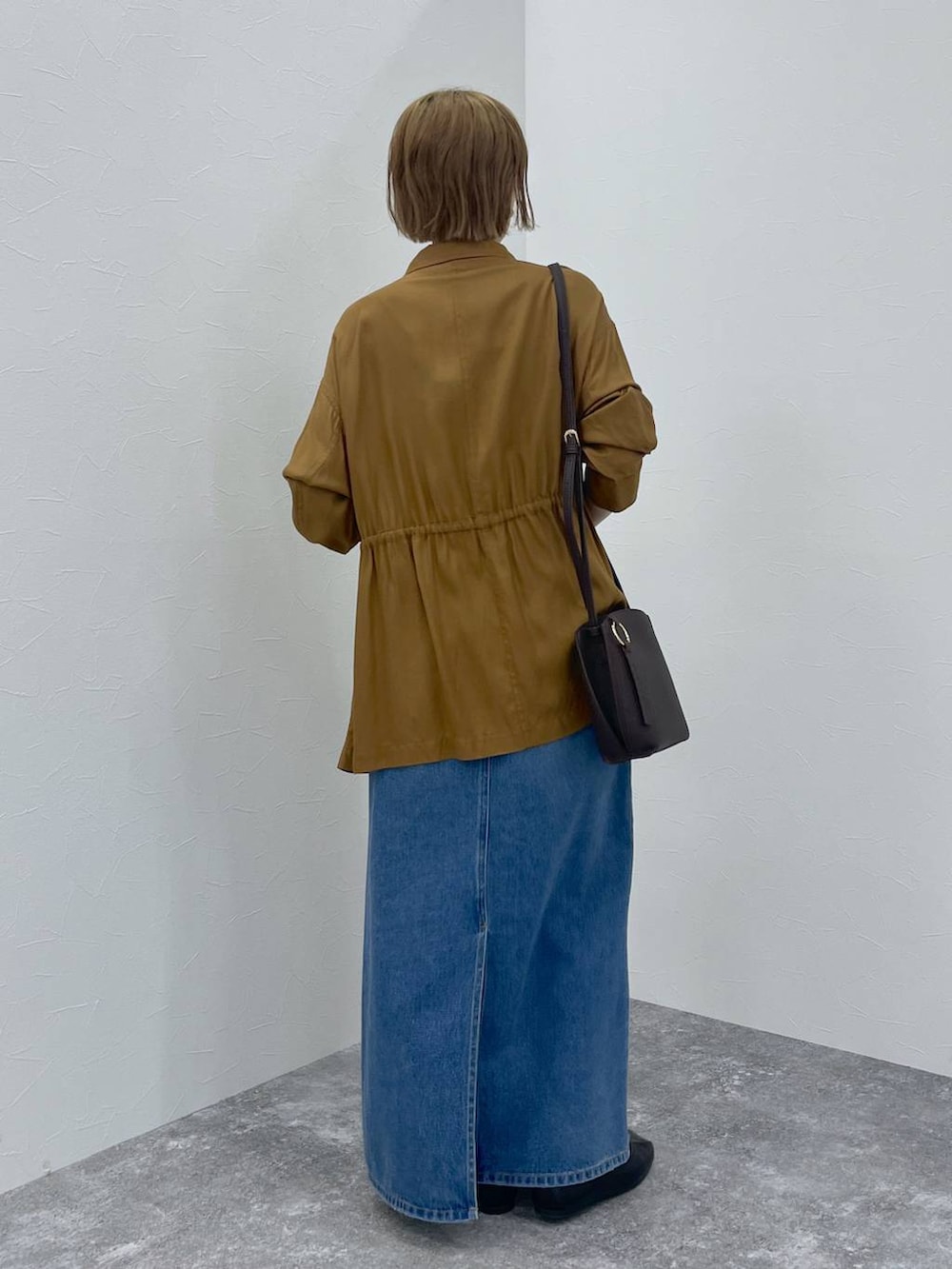 ブルー系のデニムスカート、ブラウン系のブルゾンを着用したレディースの秋コーディネートの4枚目の写真