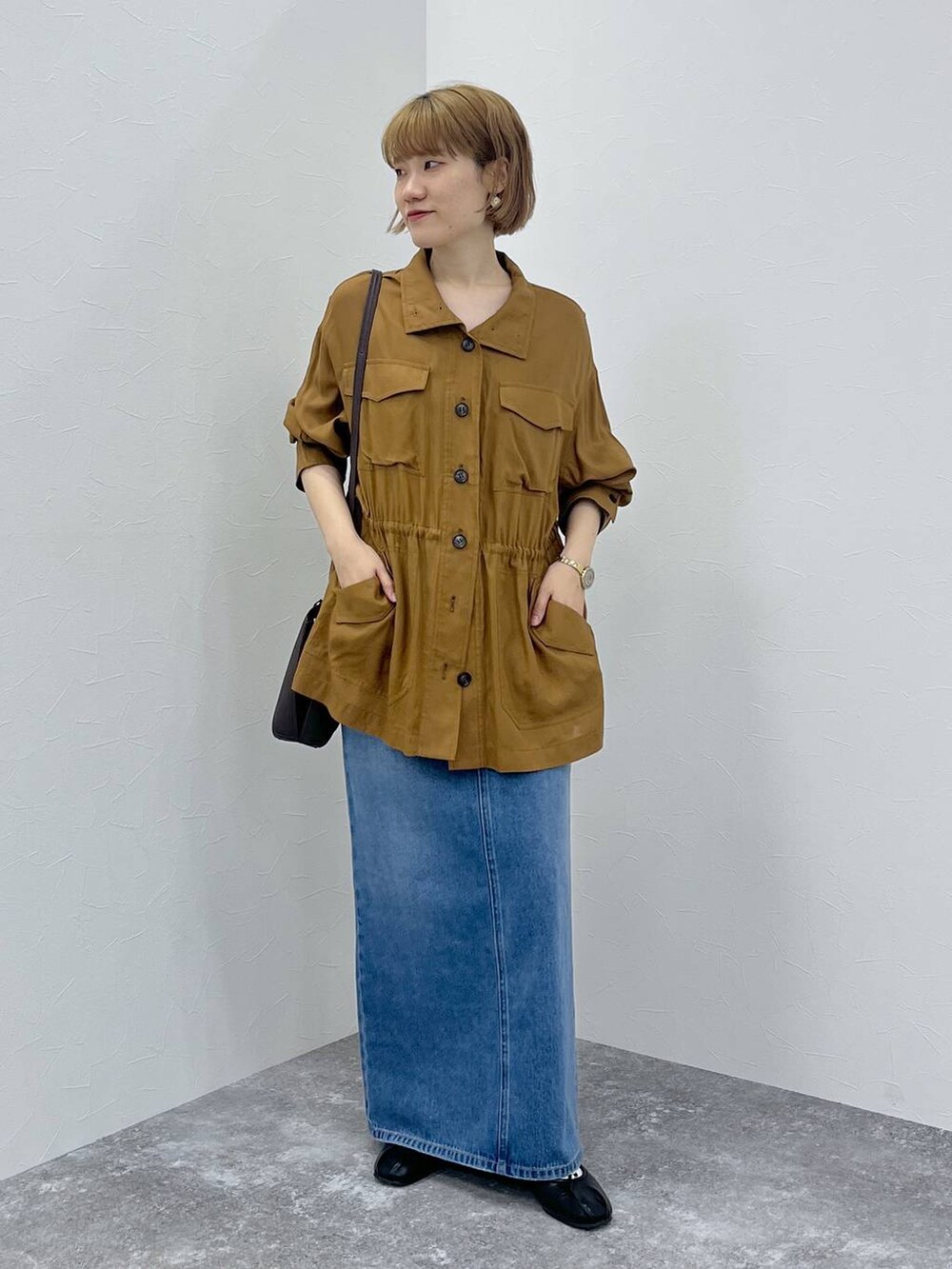 ブルー系のデニムスカート、ブラウン系のブルゾンを着用したレディースの秋コーディネートの2枚目の写真