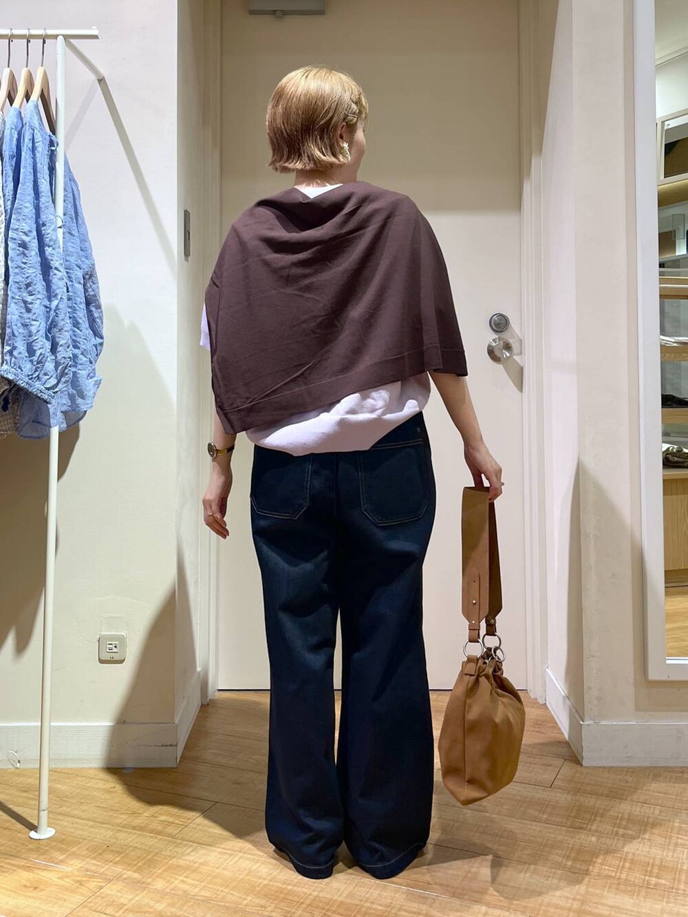 ブルー系のデニムパンツ、パープル系のスウェット、ブラウン系のショルダーバッグを着用したレディースの秋コーディネートの3枚目の写真