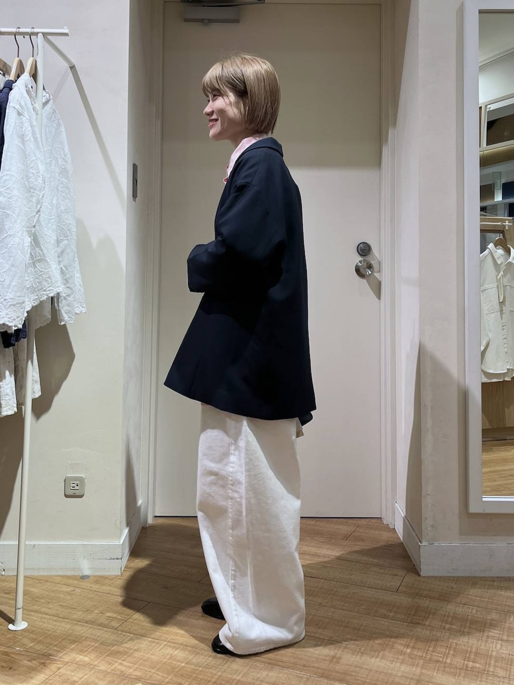 ホワイト系のデニムパンツ、ブルー系のテーラードジャケット、ブラック系のトートバッグを着用したレディースの冬コーディネートの2枚目の写真