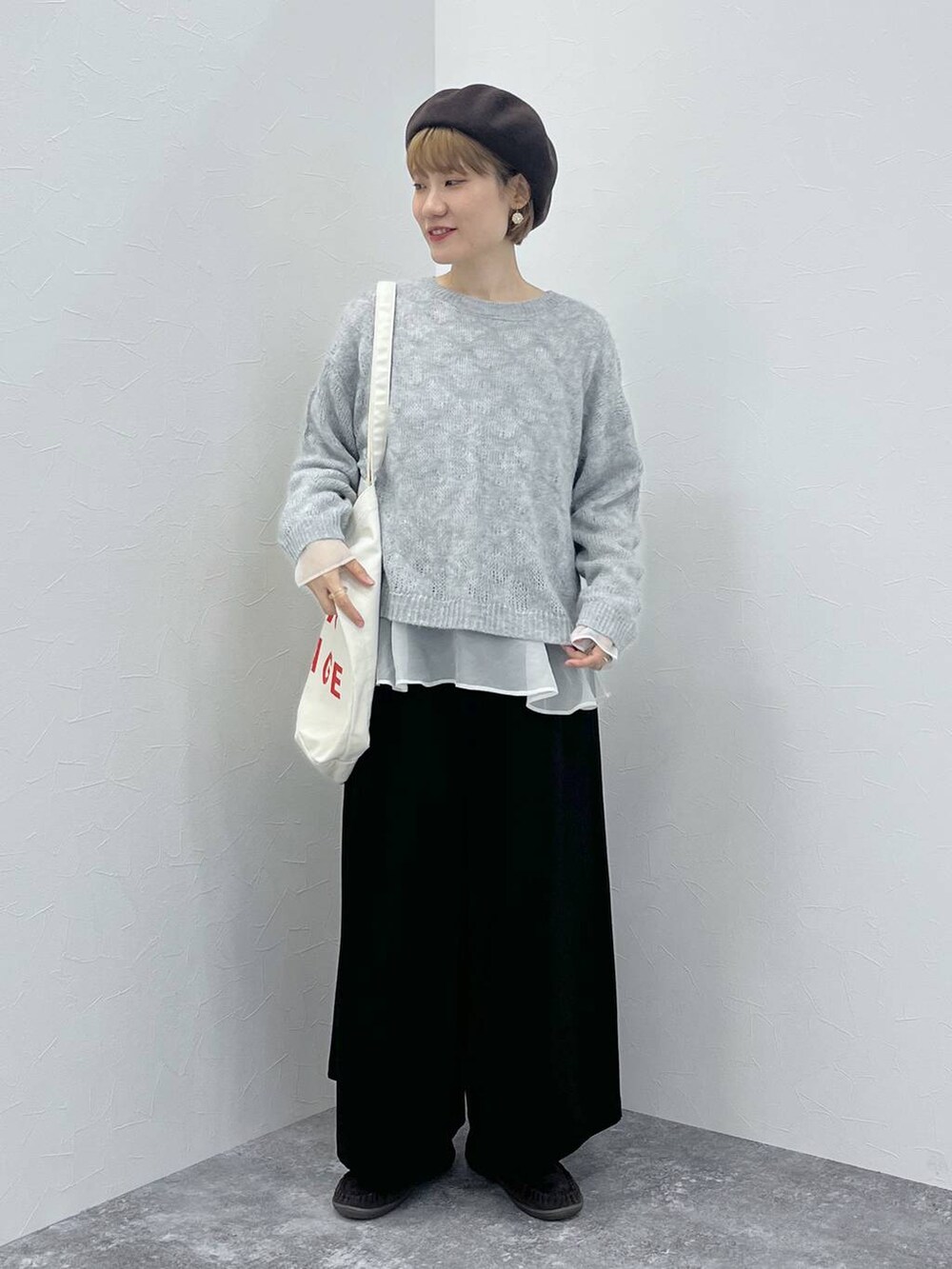 ブラック系のスーツセット、ブラウン系のモカシン/デッキシューズ、ブラウン系のハンチング/ベレー帽を着用したレディースの秋コーディネートの2枚目の写真