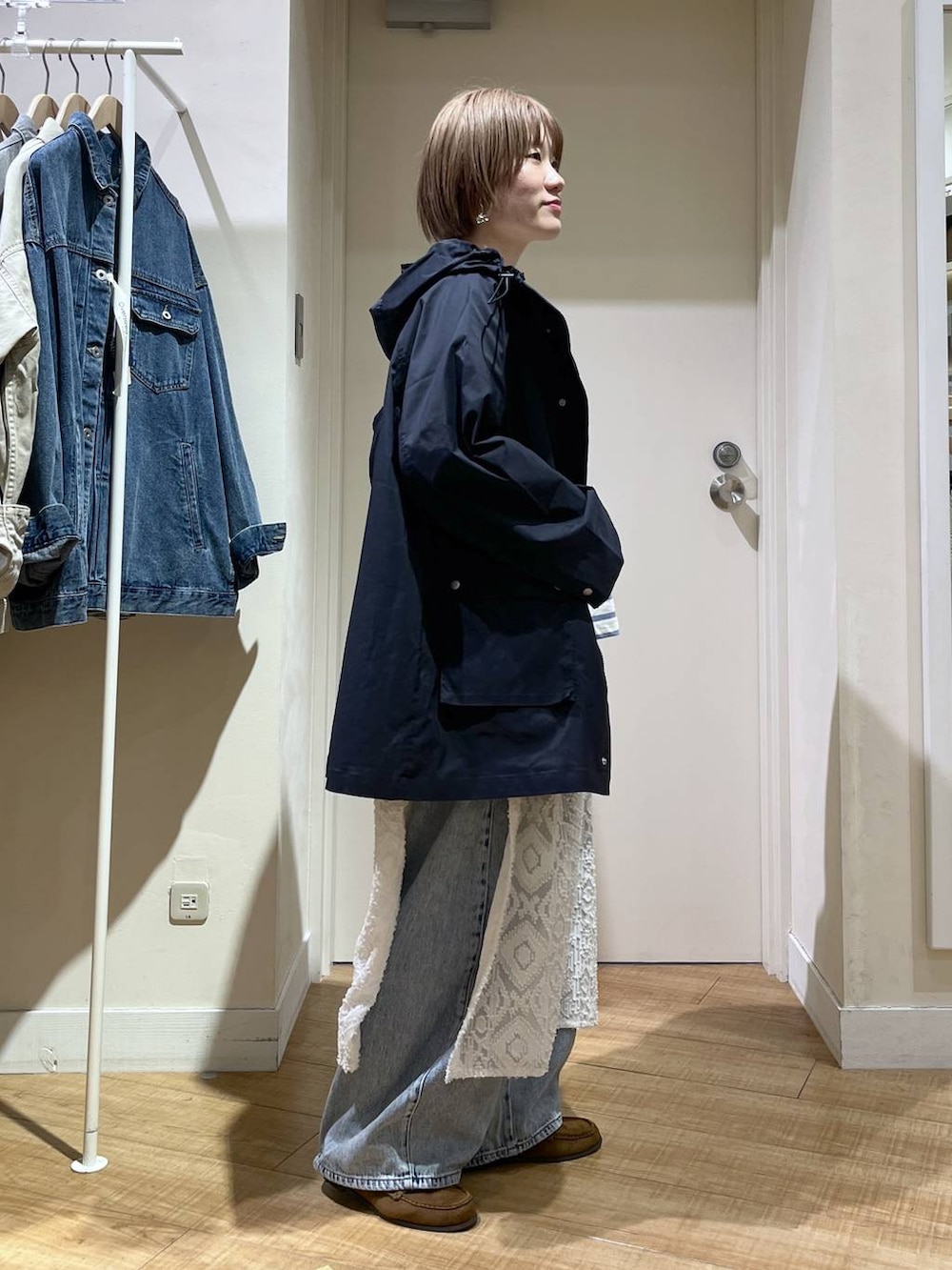 ブルー系のデニムパンツ、ブルー系のブルゾン、ホワイト系のベストを着用したレディースの春コーディネートの2枚目の写真