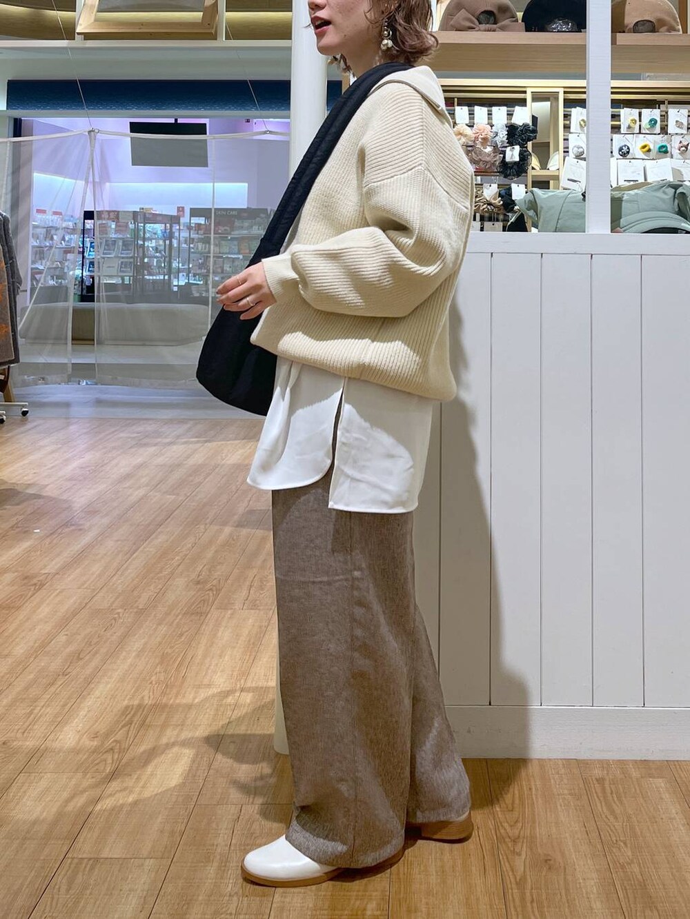 ベージュ系のスリッポン、ベージュ系のスラックス、ベージュ系のニット/セーターを着用したレディースの冬コーディネートの3枚目の写真
