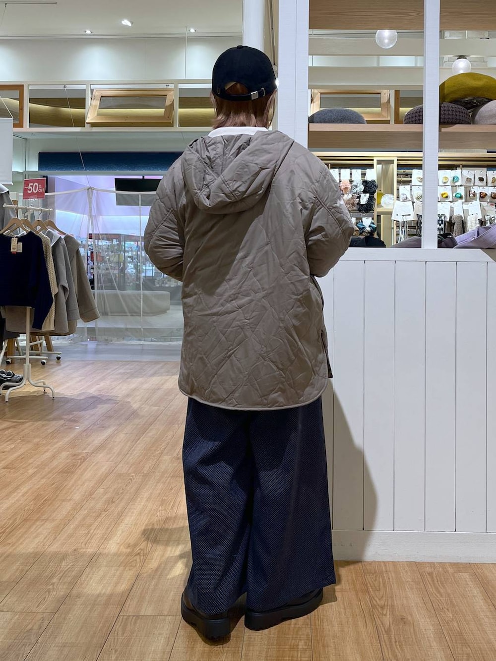 ブラウン系のブルゾン、ホワイト系のTシャツ/カットソー、ブラック系のブーツを着用したレディースの冬コーディネートの3枚目の写真