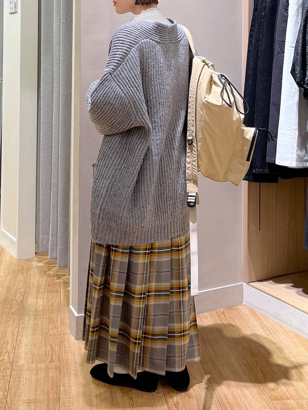 グレー系のその他アウター、ベージュ系のバックパック/リュック、ブラック系のパンプスを着用したレディースの秋コーディネートの2枚目の写真