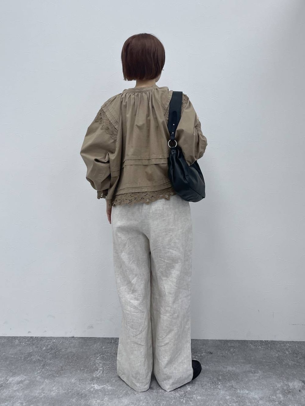 ブラック系のトートバッグ、ブラック系のローファー、ベージュ系のシャツ/ブラウスを着用したレディースの春コーディネートの3枚目の写真