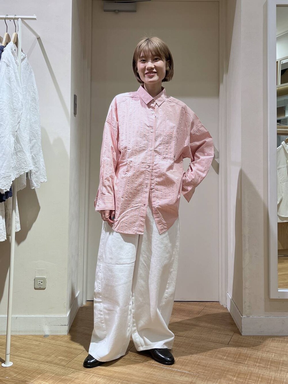 ホワイト系のデニムパンツ、ブルー系のテーラードジャケット、ブラック系のトートバッグを着用したレディースの冬コーディネートの4枚目の写真